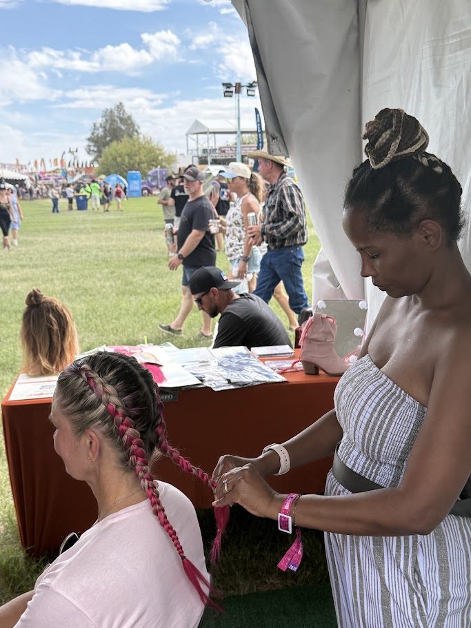 Braidful stylist braiding pink feed-in braids at Country Thunder AZ